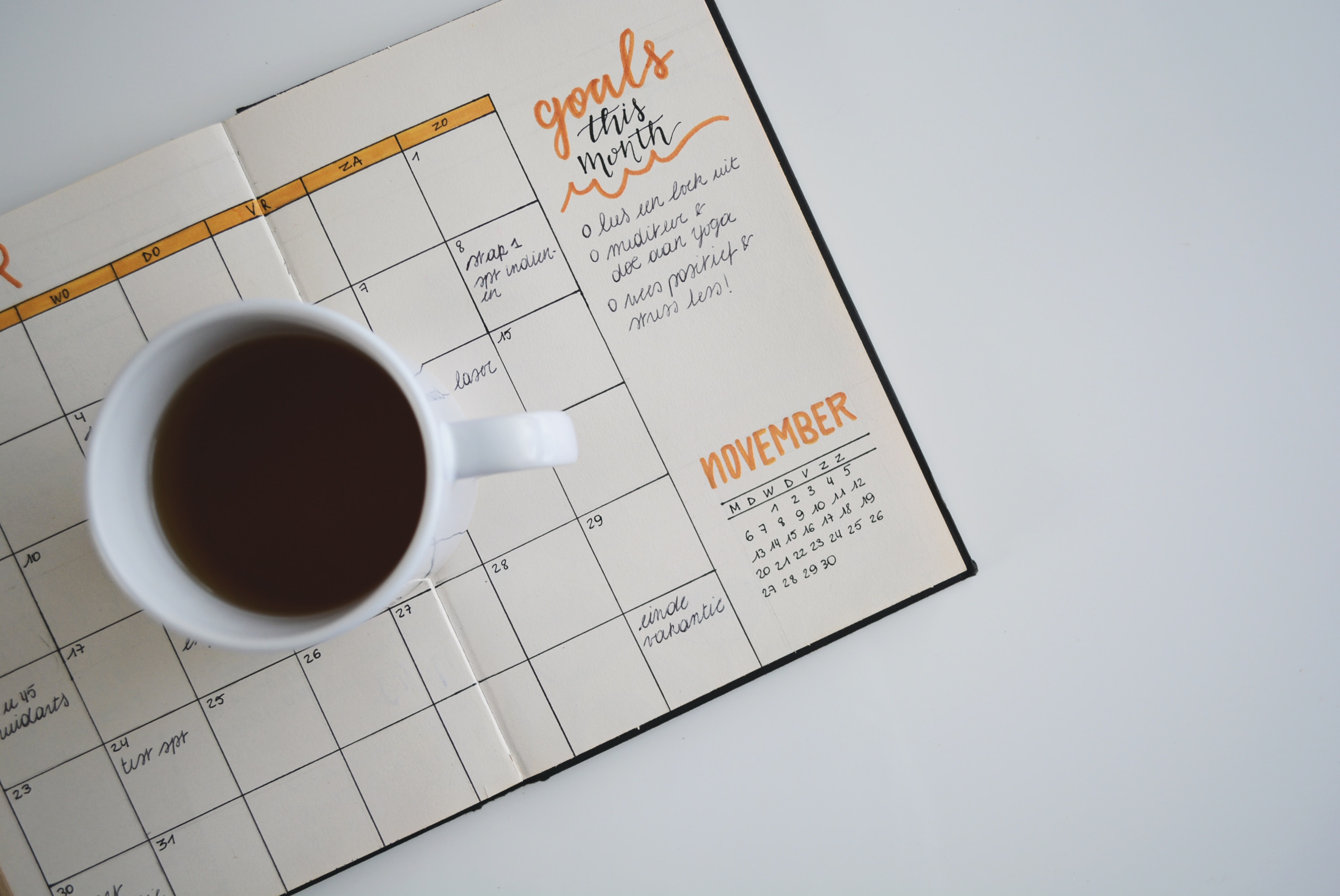 personal calendar open, there is a coffee mug over it