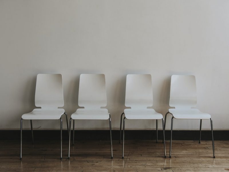 four white chairs against a white wall