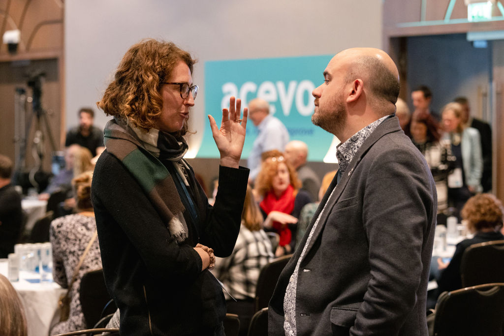 two people standing up, having a conversation