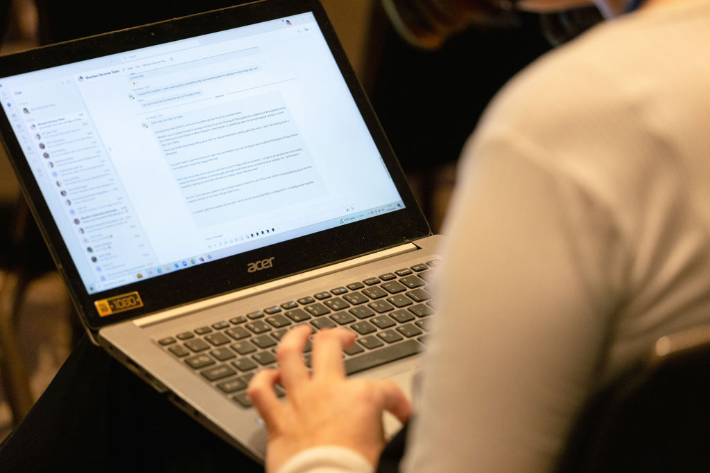 person taking notes using a laptop